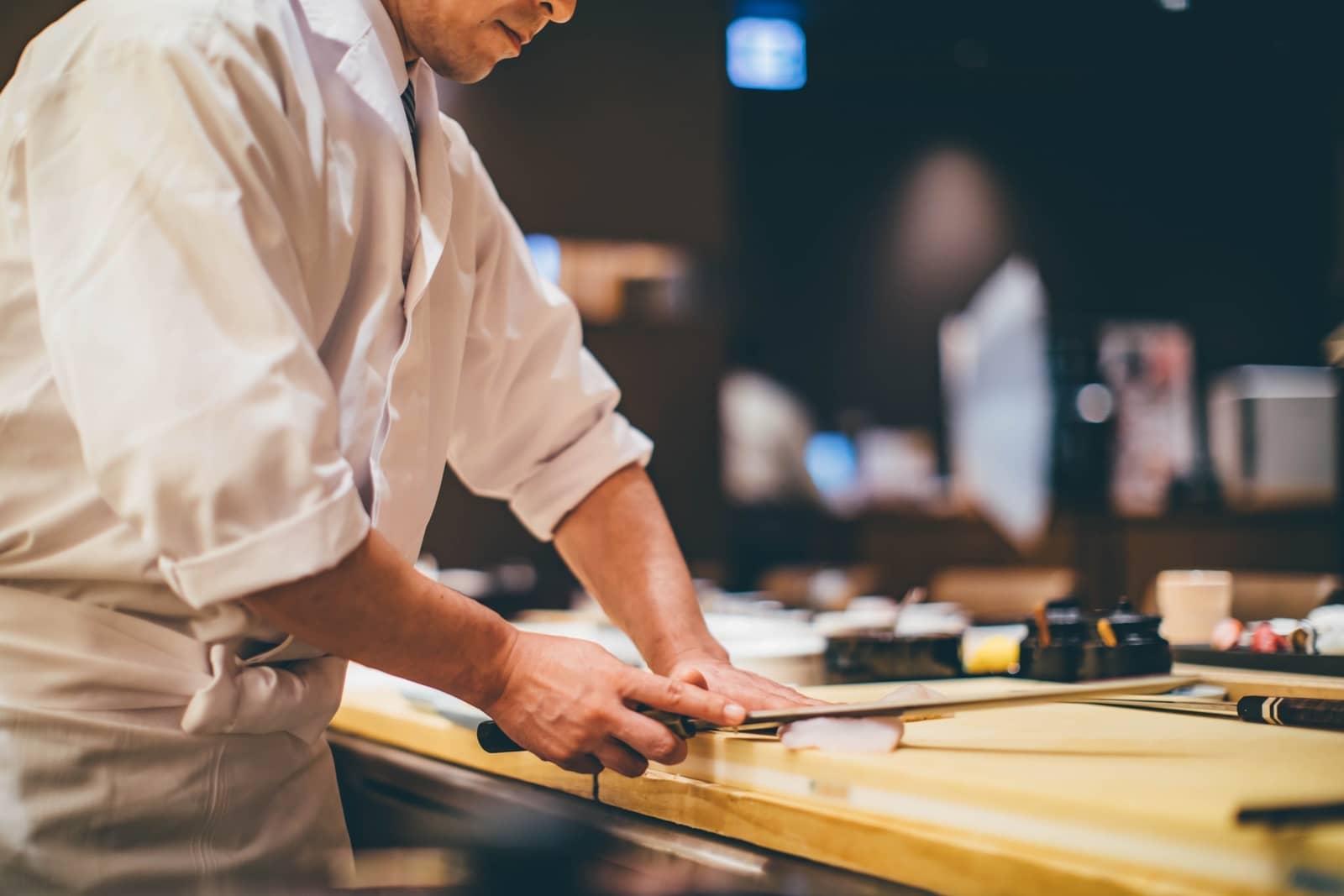 Sushi chef cutting fish