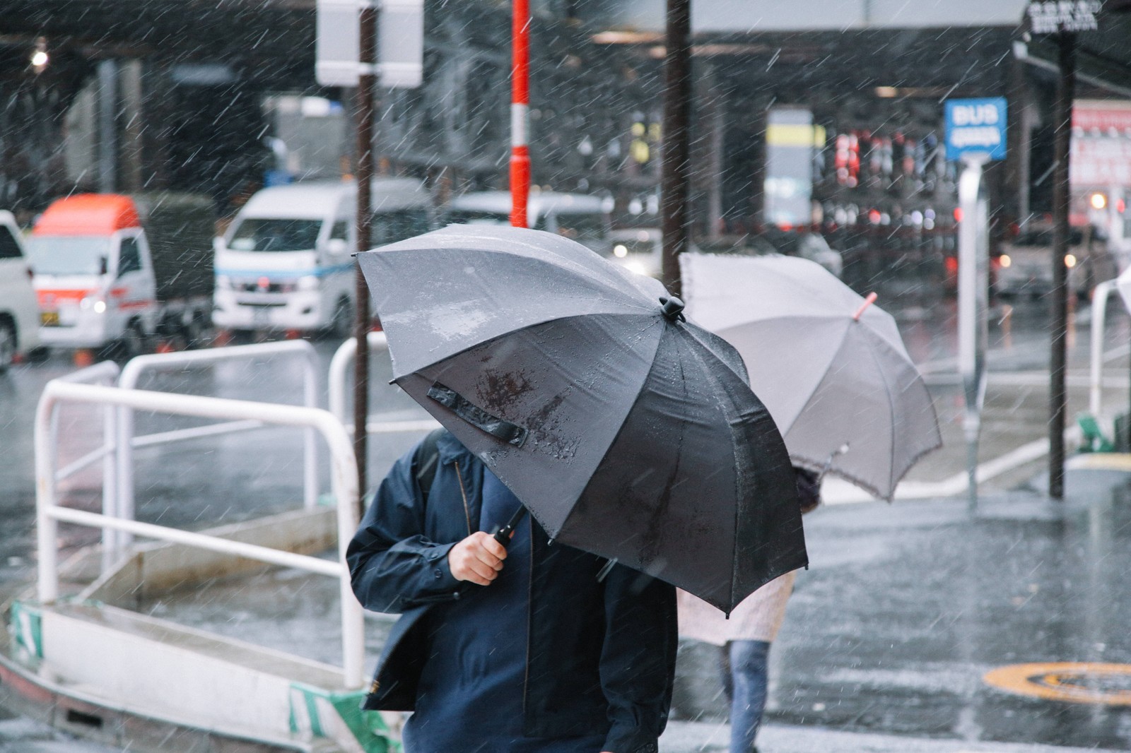 passengers walking in heavy rain and wind