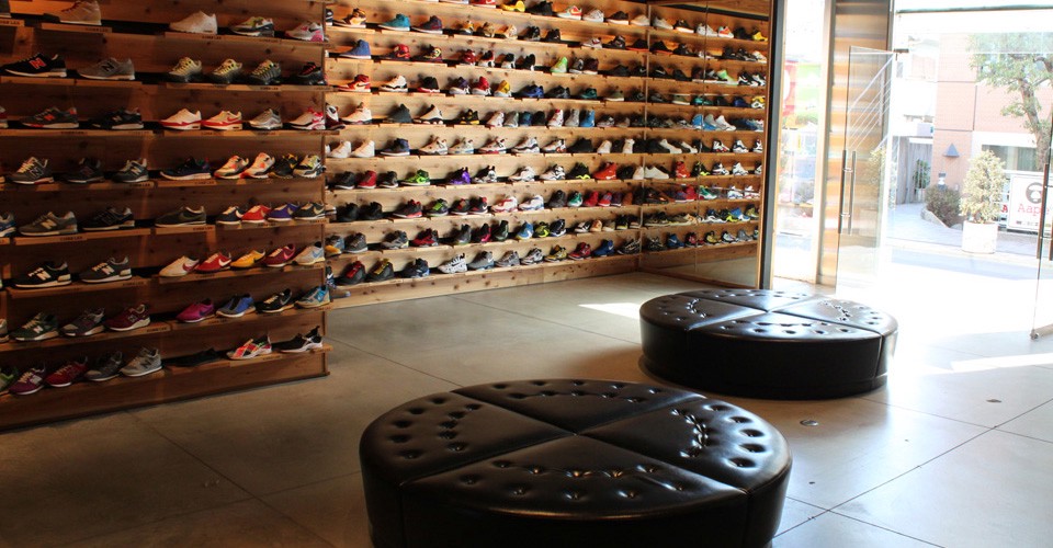 Sneakers displayed on the wooden wall at Kicks Lab