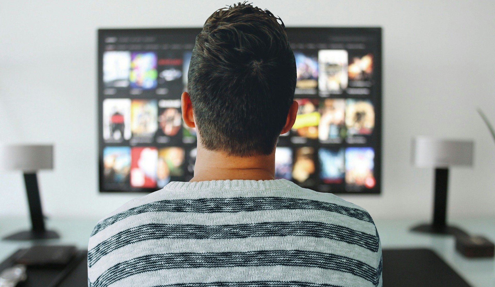 A man watching film lists on Netflix