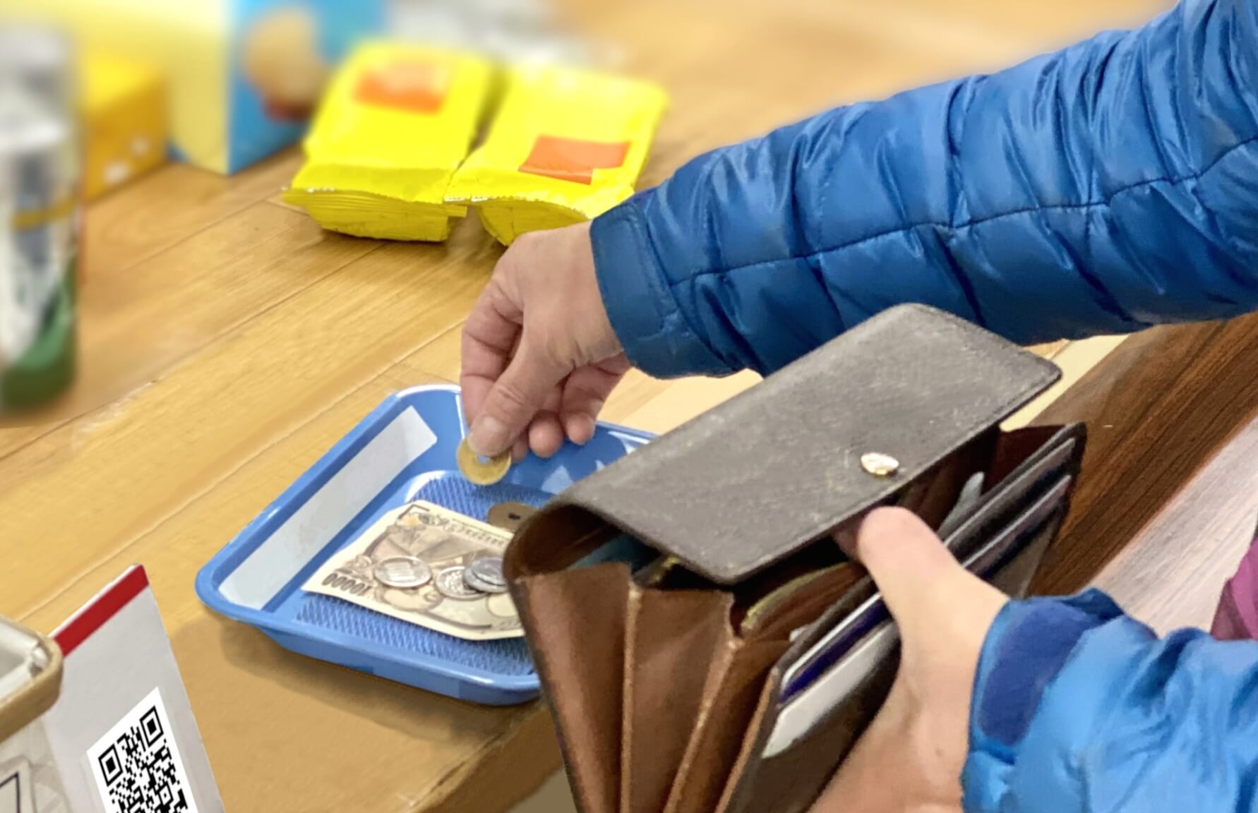 Shopper leaving money in cashier's tray in Japan