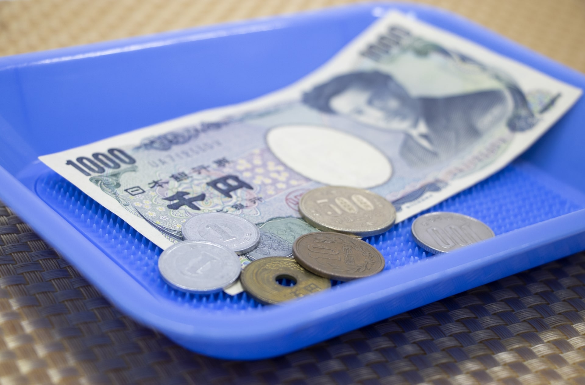 Japanese bills and coins in a plastic tray