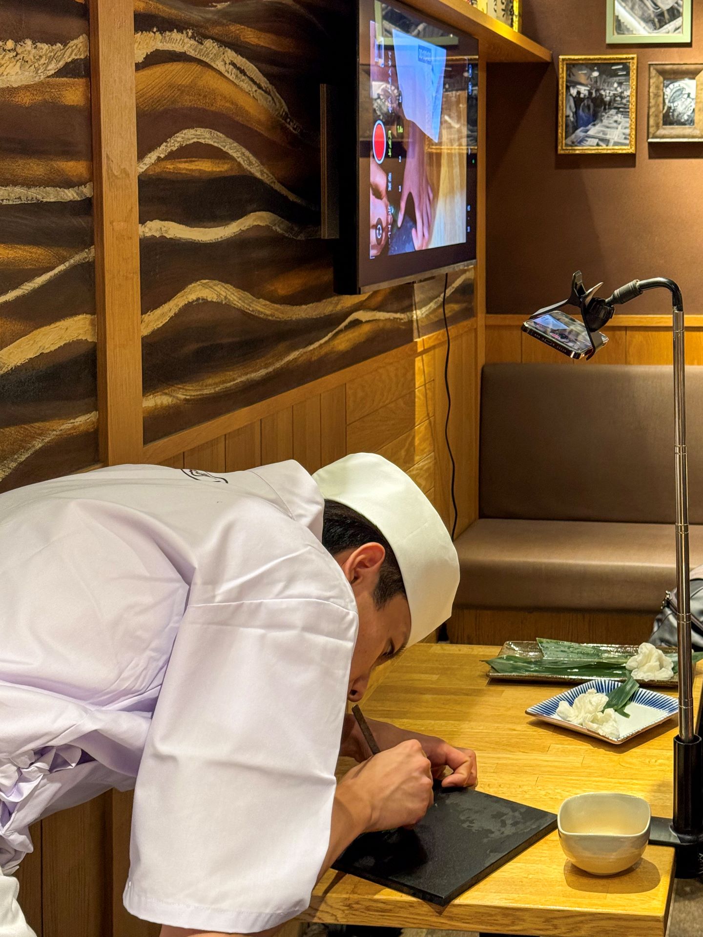 Sushi chef creating an intricate decoration with a bamboo leaf