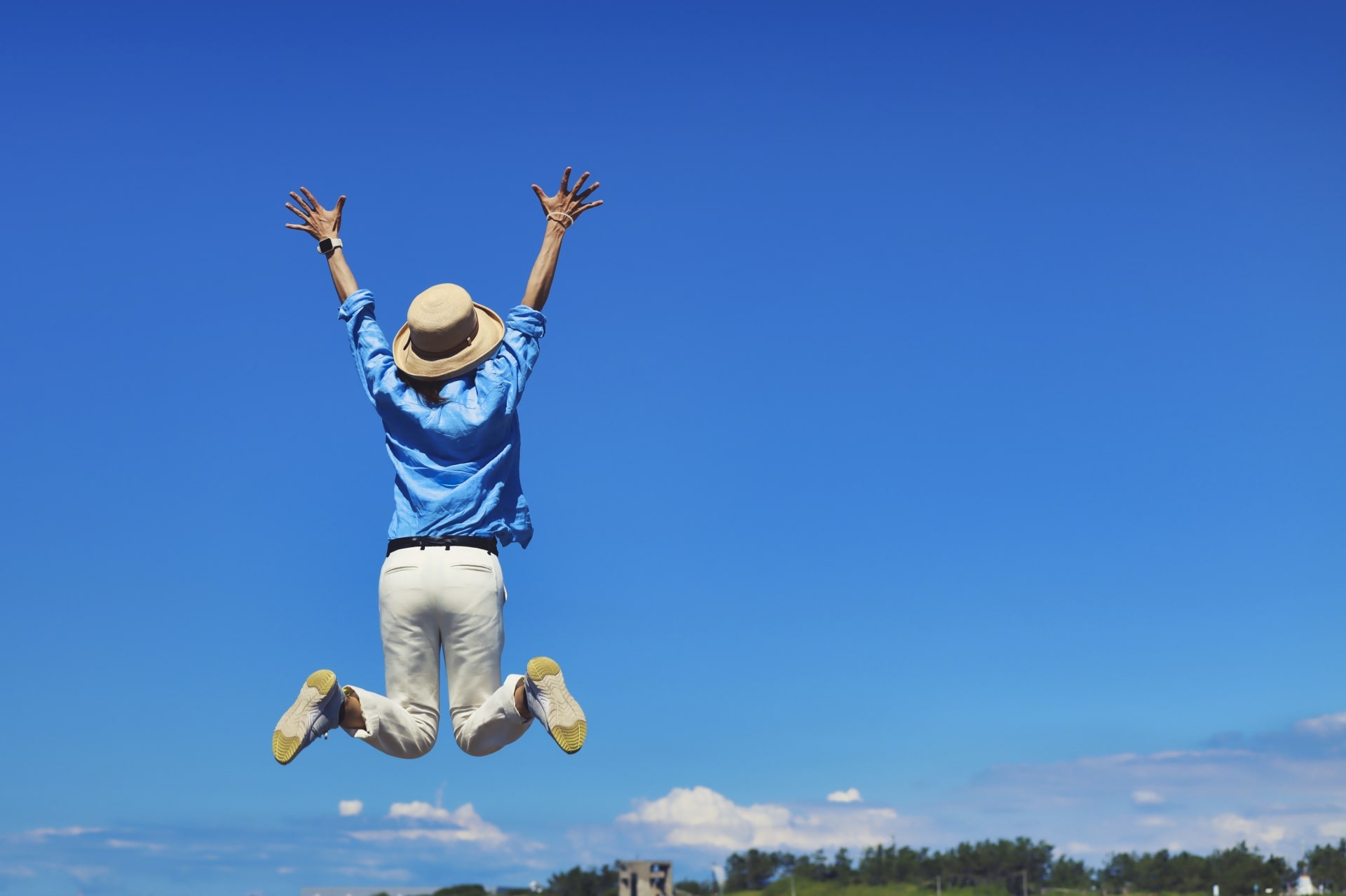 Happy traveler jumping with a blue sky in the background