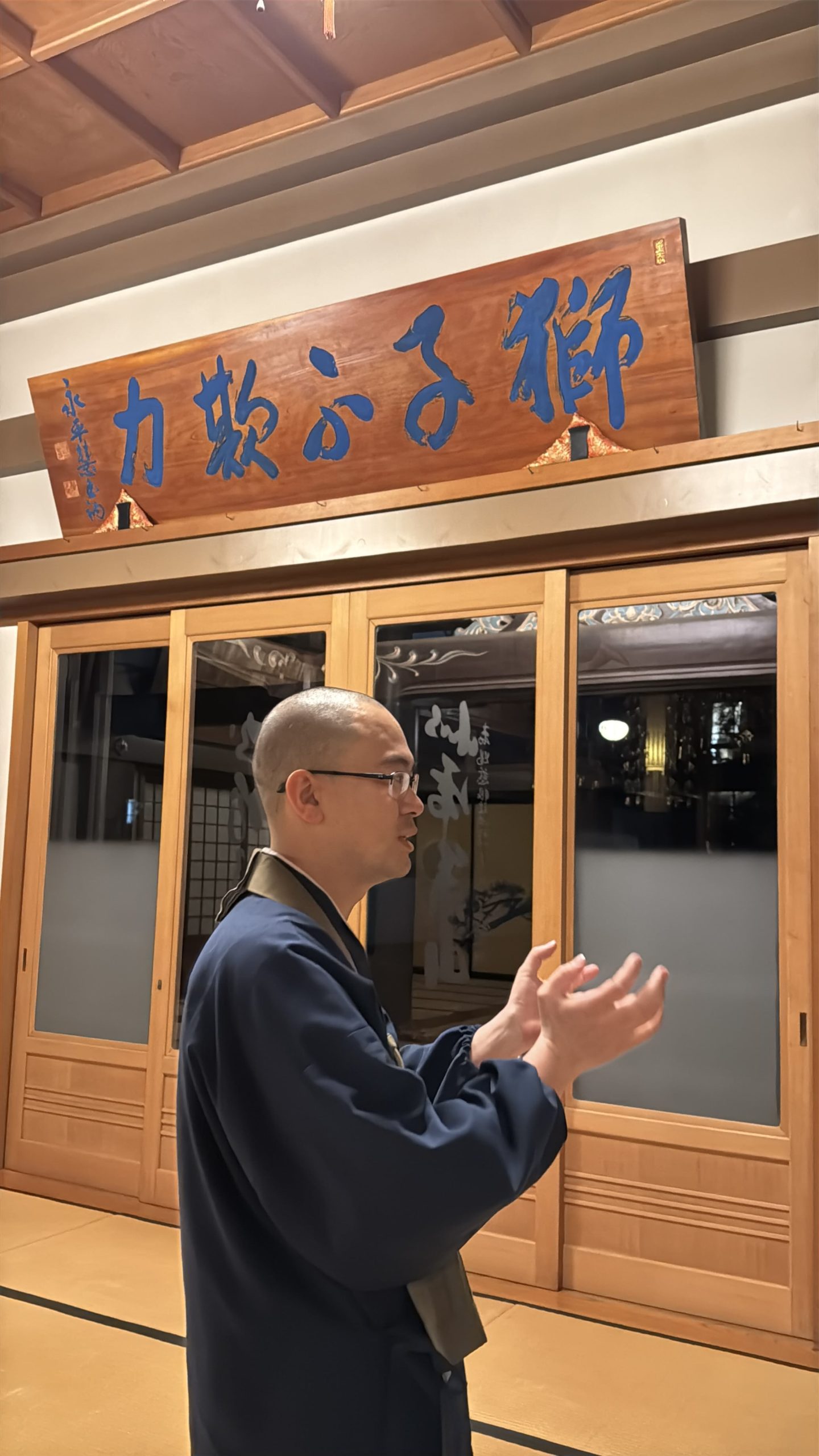 Monk showing around the main hall of Denchuji temple