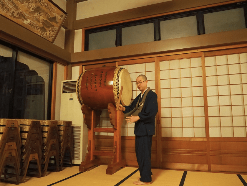 Monk showing around the main hall of Denchuji temple